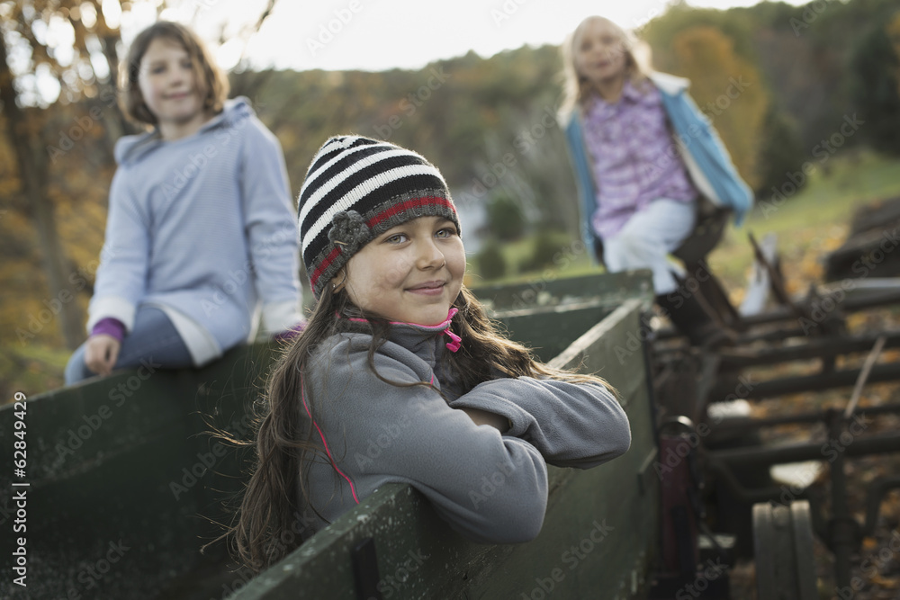 Three young girls out and about on the farm. On an old trailer. Three young girls out and about on the farm. On an old trailer.