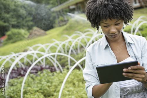Woman using digital tablet in horticultural nursery