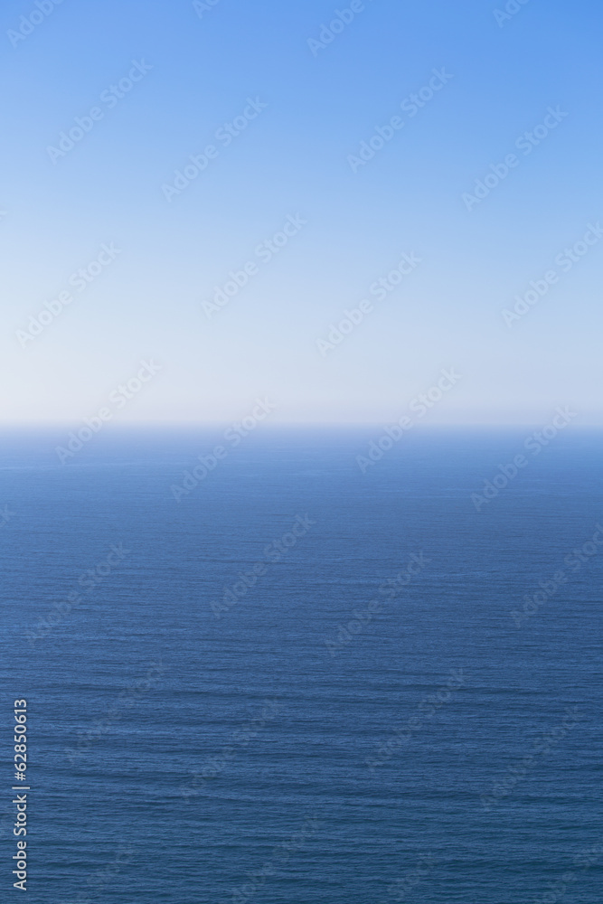 A view over the Pacific Ocean and a calm sea, merging into the blue sky. A view over the Pacific Ocean and a calm sea, merging into the blue sky.