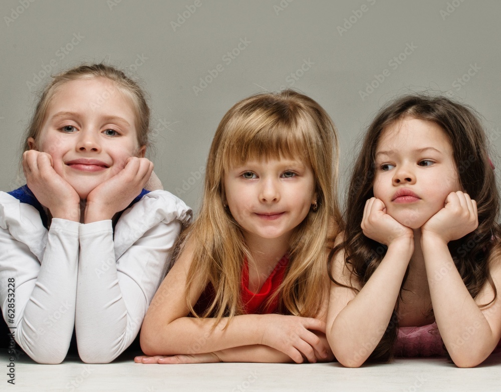 Three little girls isolated on grey background Three little girls isolated on grey background