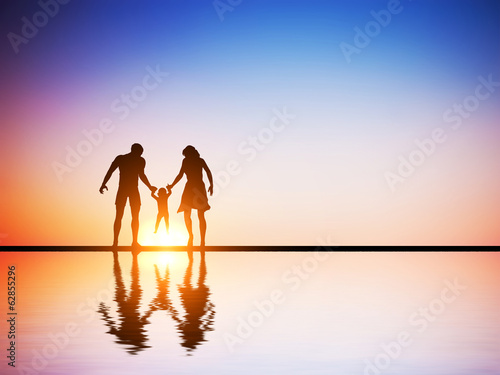 Happy family together, parents and their child at sunset, photo