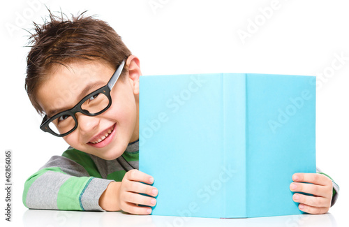 Little boy plays with book