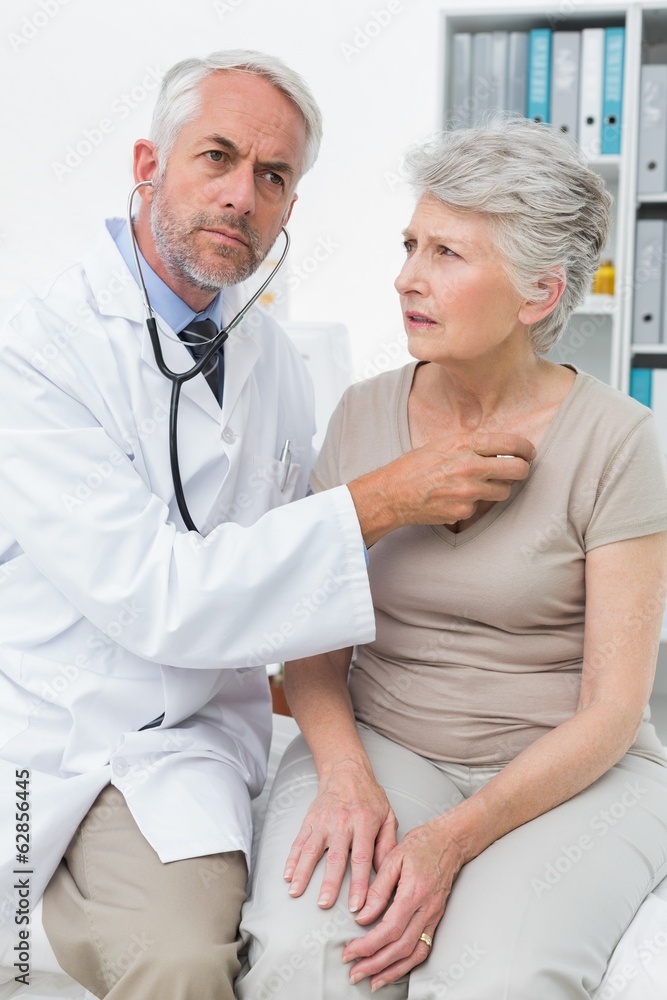 Obraz premium Doctor checking patients heartbeat using stethoscope