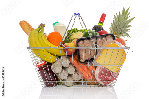 Schilderij op canvas Shopping basket full of fresh food isolated on white.