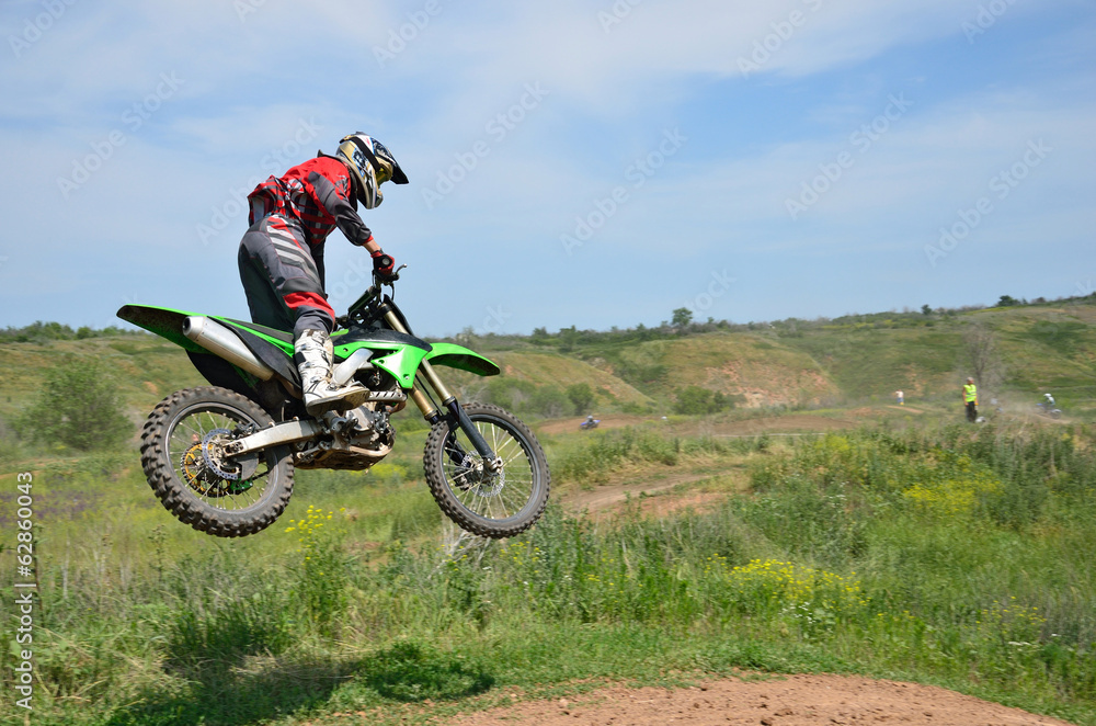 X games driver standing on the MX motorcycle is flying over the X games driver standing on the MX motorcycle is flying over the