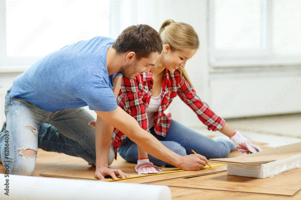 smiling couple measuring wood flooring smiling couple measuring wood flooring