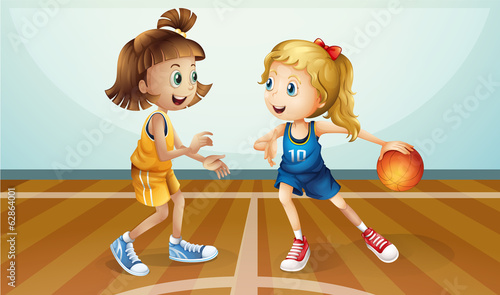 Two young ladies playing basketball