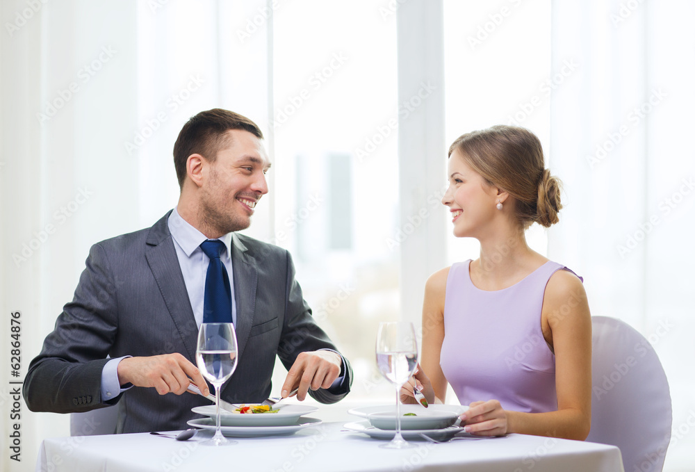 smiling couple eating appetizers at restaurant smiling couple eating appetizers at restaurant