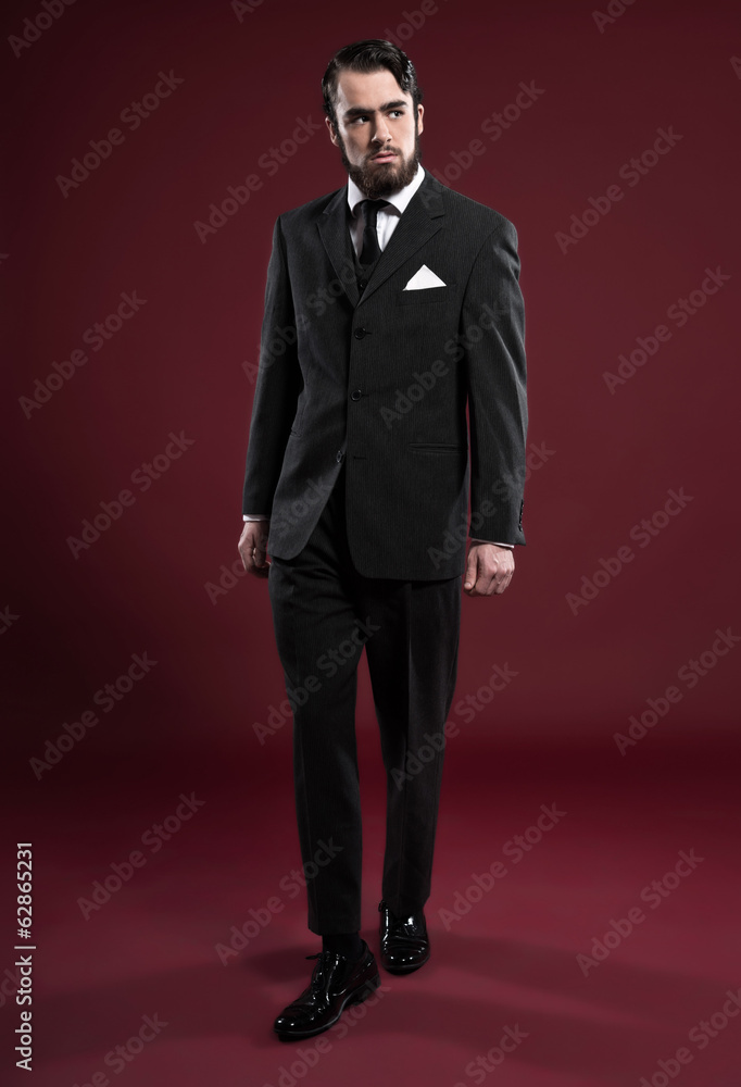 Retro 1900 fashion man with beard wearing grey suit and black ti Retro 1900 fashion man with beard wearing grey suit and black ti