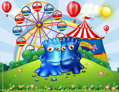 Two monsters at the hilltop with an amusement park