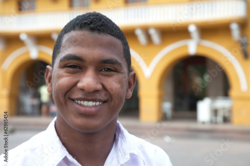 Sticker Young guy in a colonial town laughing at camera