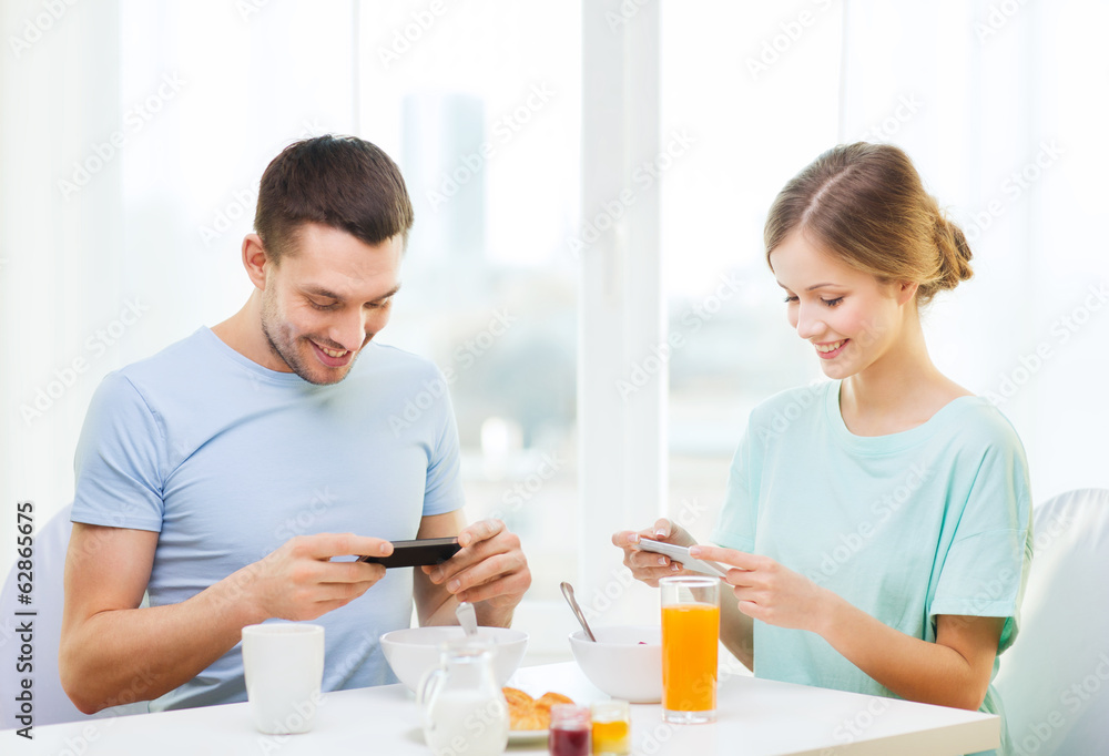 smiling couple with smartphones taking picture smiling couple with smartphones taking picture