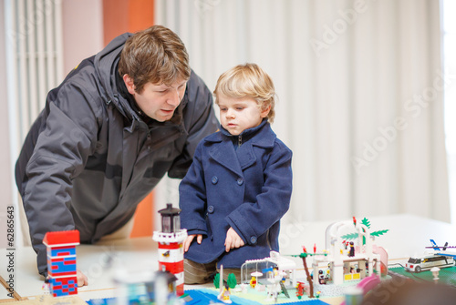 Father and  little son having fun on toy exposition, indoors. photo