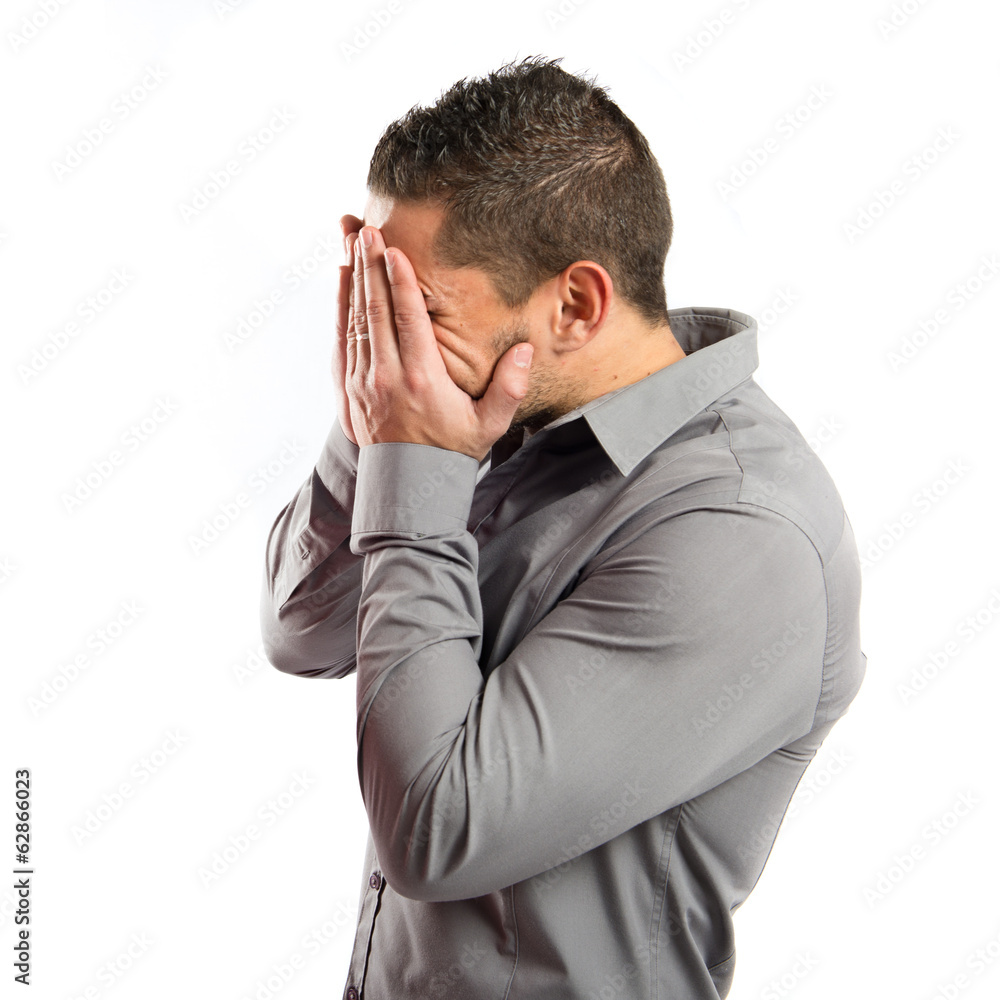 Men covering his eyes over white background Men covering his eyes over white background