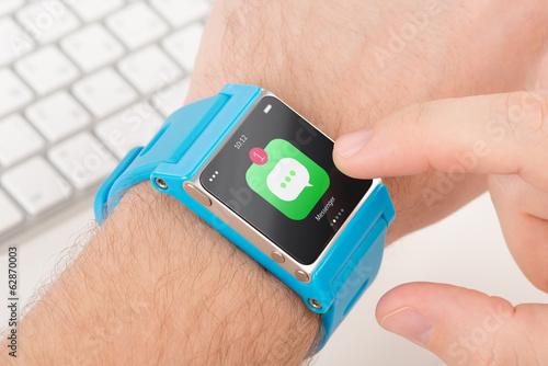 Finger taps messenger icon on blue smart watch