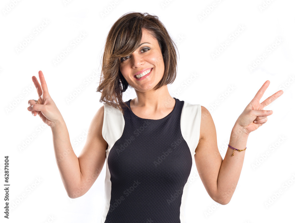 Pretty woman making the victory gesture over white background Pretty woman making the victory gesture over white background