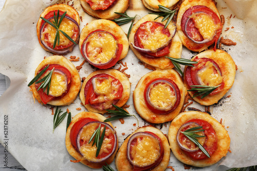 Small pizzas on baking paper close up