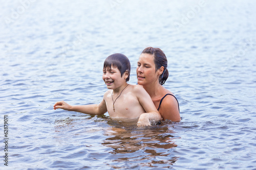 Mother and son swimming in the lake