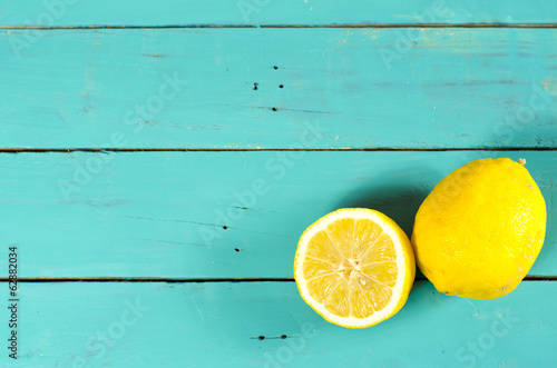 Freshly cut half and whole lemons on rustic boards.
