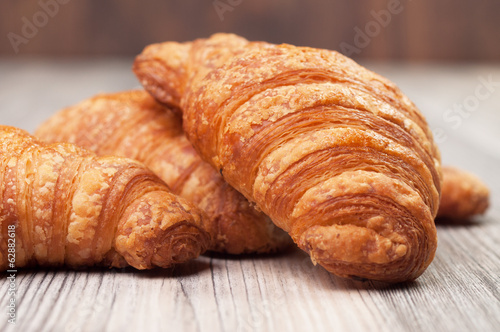 Several croissants on a wooden surface