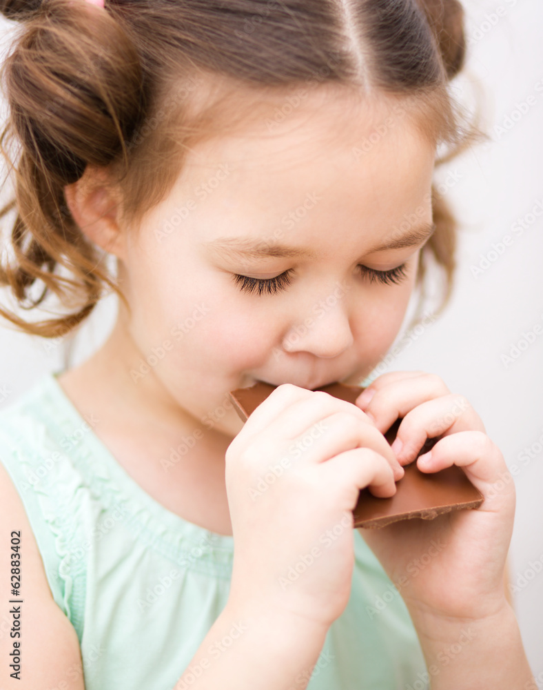 Cute girl is eating chocolate candy Cute girl is eating chocolate candy