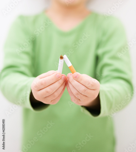 Young girl is breaking a cigarette