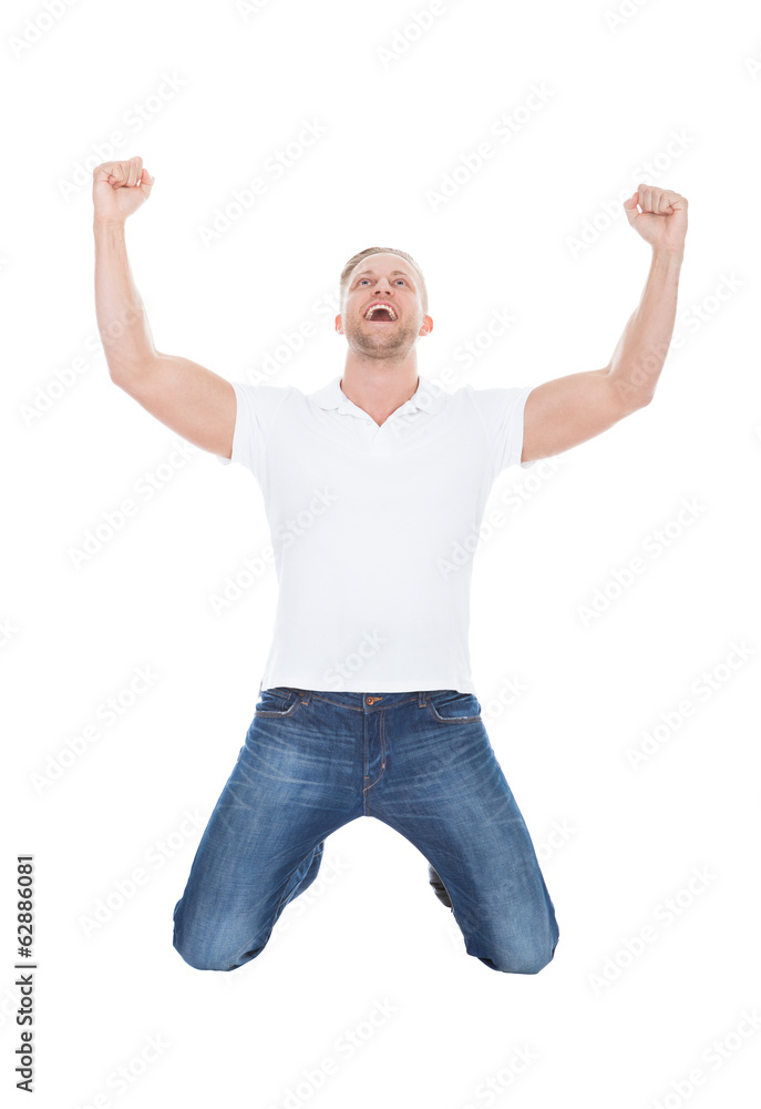 Excited man cheering in jubilation dropping down on his knees Excited man cheering in jubilation dropping down on his knees