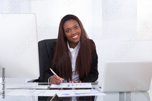 Confident businesswoman working at desk in office