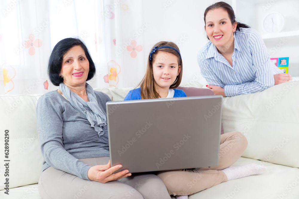 grandmother mother and daughter using laptop at home grandmother mother and daughter using laptop at home