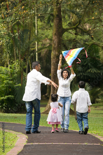 indian family playing kite in the outdoor park