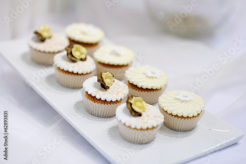 Decorated white vanilla cream cupcakes on a plate