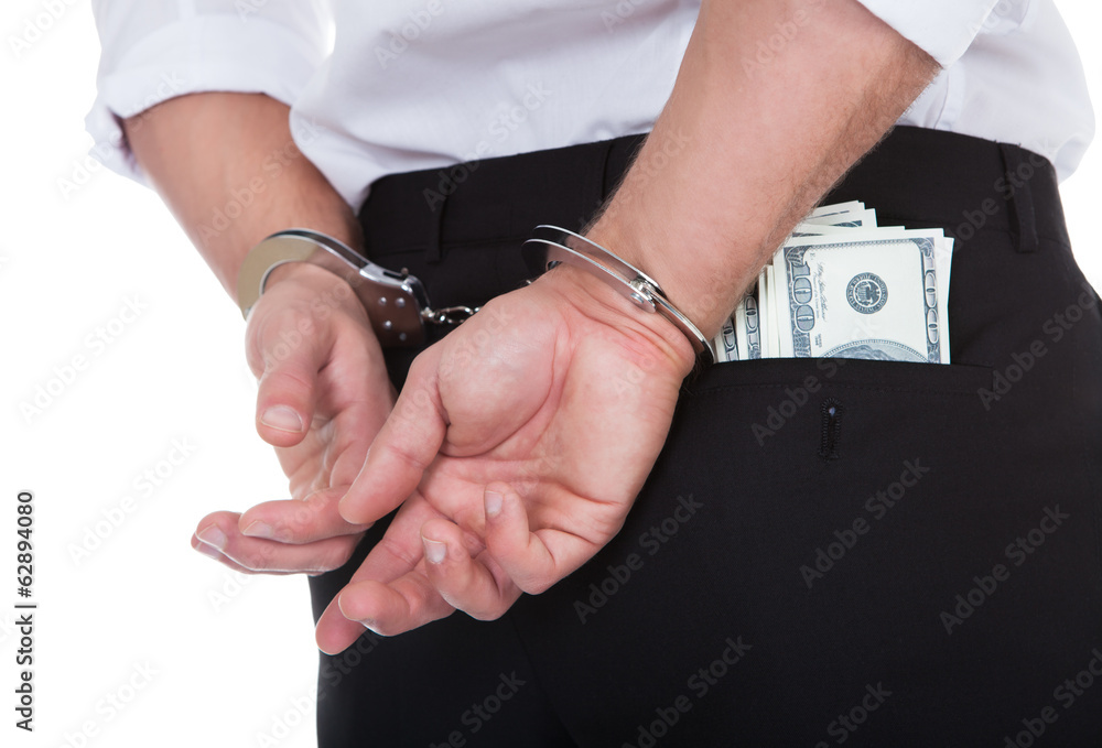 Man in handcuffs with banknotes in his pocket Man in handcuffs with banknotes in his pocket