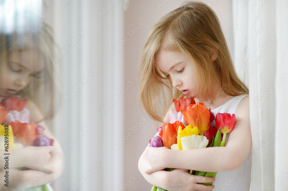 Adorable little girl with tulips by the window Adorable little girl with tulips by the window