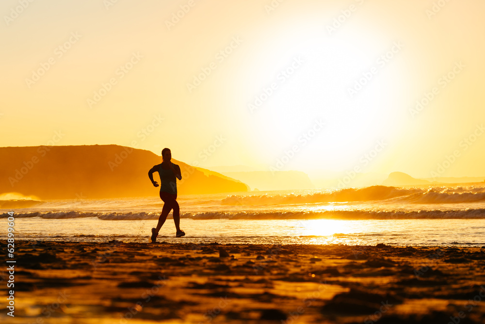 Runner on beach at sunset