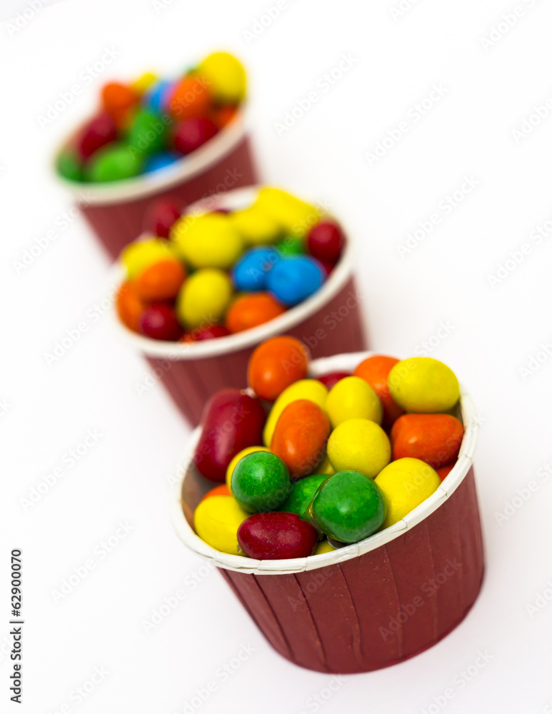 Isolated colorful candy in paper cup - selective focus Isolated colorful candy in paper cup - selective focus