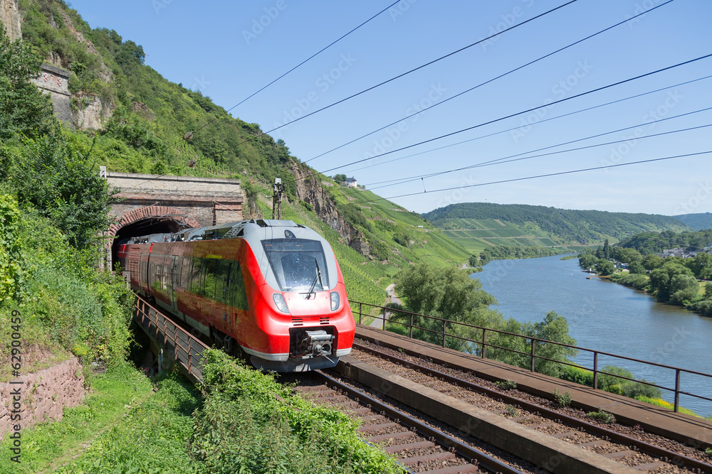 Naklejka premium Pociąg opuszczający tunel wzdłuż rzeki Mozeli w Niemczech