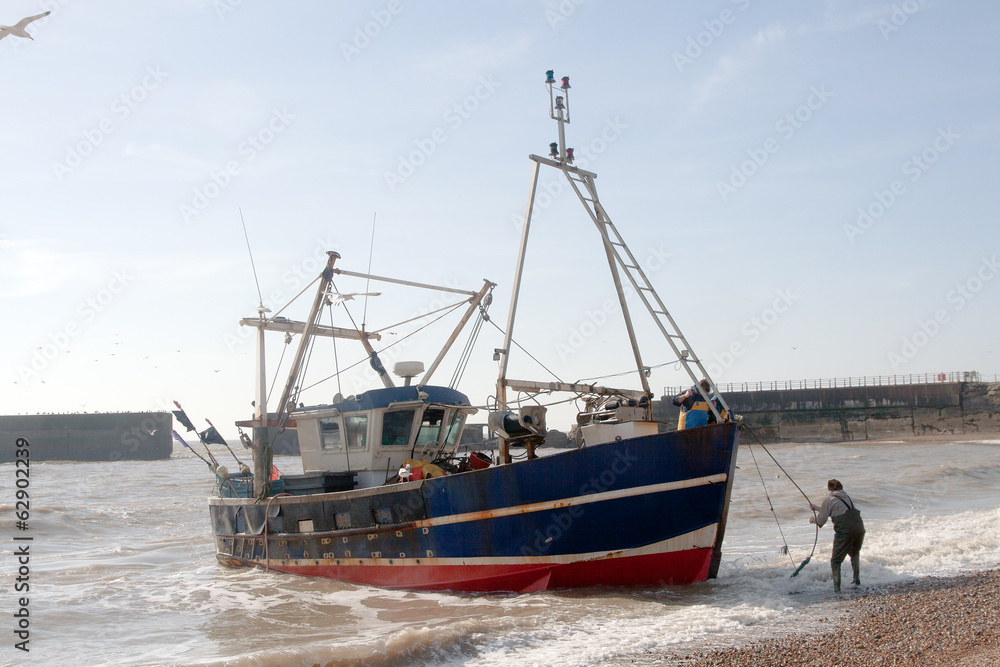 Fishing boat being landed on beach