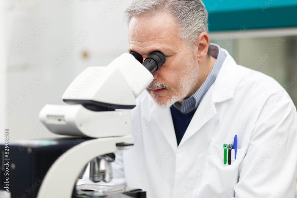 Scientist conducting research looking through microscope Scientist conducting research looking through microscope