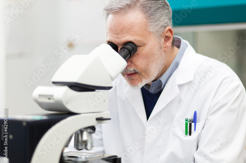 Scientist conducting research looking through microscope