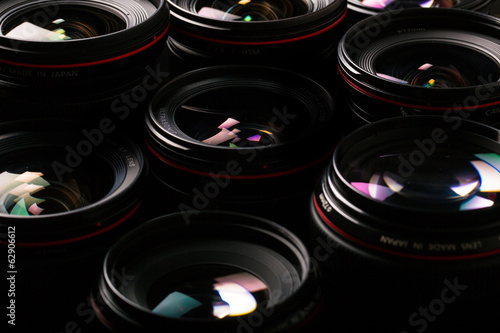 Modern camera lenses with reflections, low key image