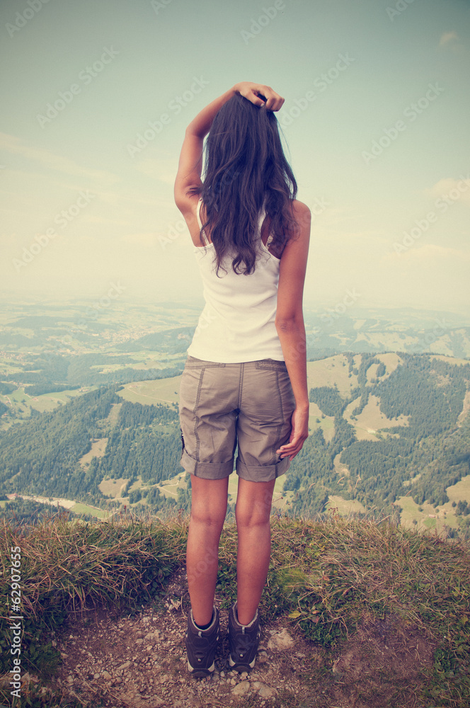 Rear view of standing long hair woman against sky and landscape