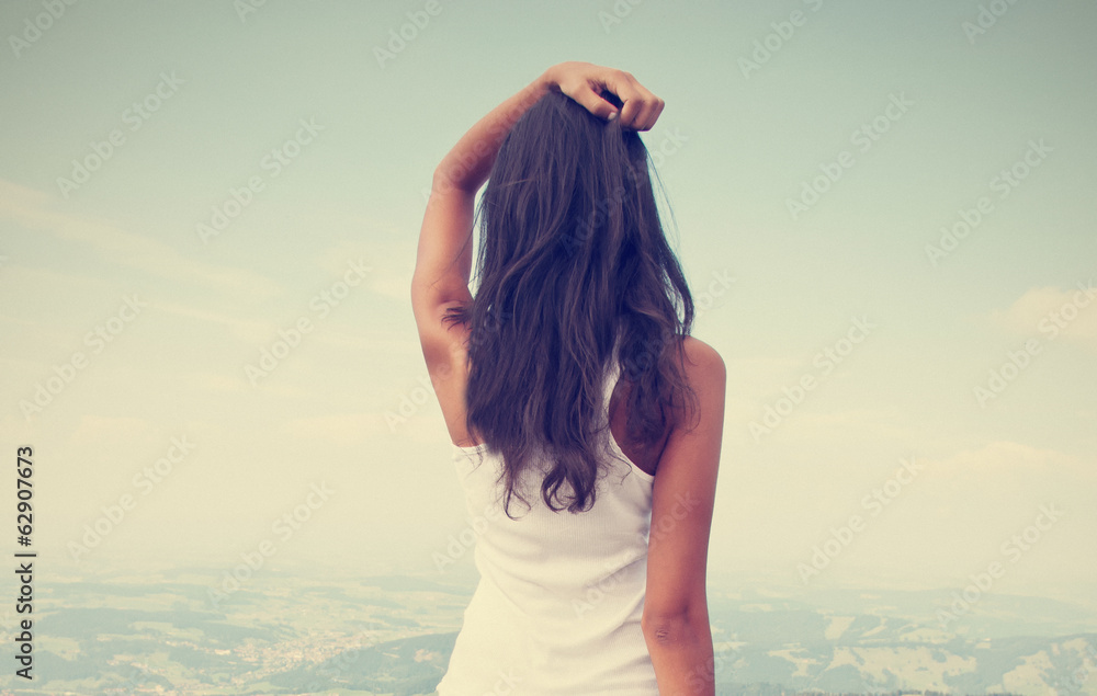 Obraz premium Rear view of standing long hair woman against sky and landscape