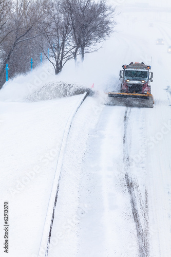 Snowplow removing the Snow from the Highway during a Snowstorm © aetb