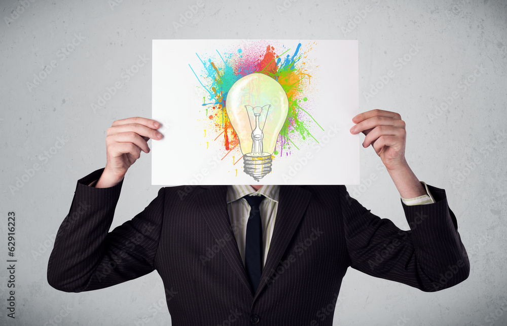 Businessman holding a cardboard with paint splashes and lightbul Businessman holding a cardboard with paint splashes and lightbul