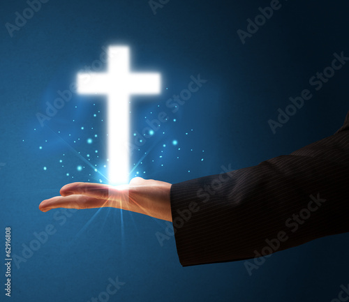 Fototapeta Naklejka Na Ścianę i Meble -  Glowing cross in the hand of a businessman
