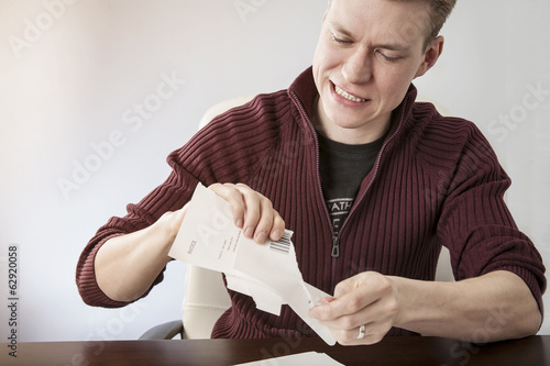 Frustrated angry man ripping bills