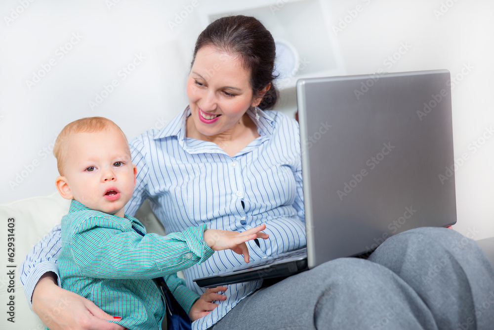 Young business woman with laptop and her baby boy Young business woman with laptop and her baby boy