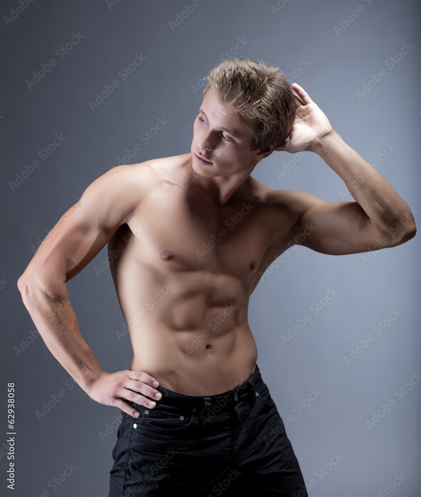 Attractive muscular man posing with naked torso