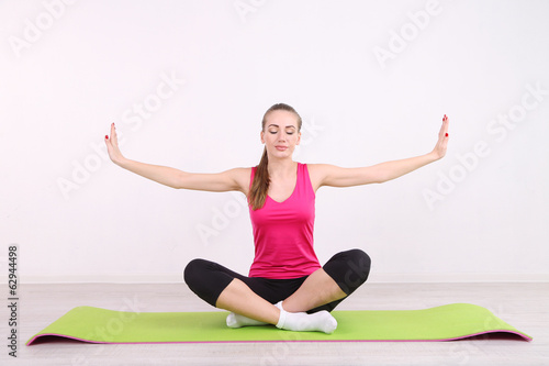 Young beautiful fitness girl exercising in gym