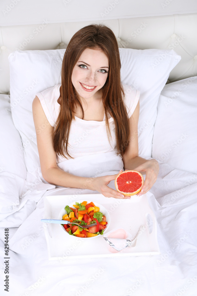Young beautiful woman in bed with light breakfast Young beautiful woman in bed with light breakfast